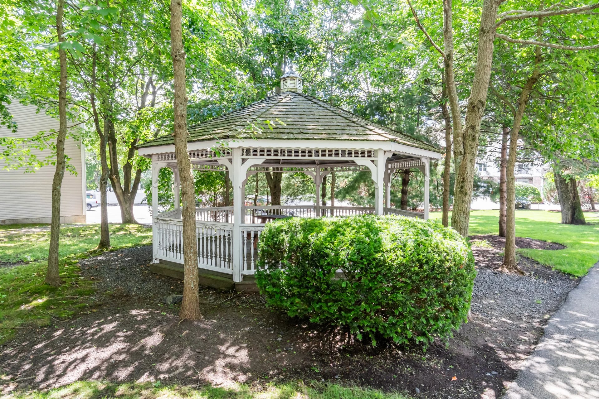 The community gazebo among the trees on the wooded grounds at Chestnut Park Apartments