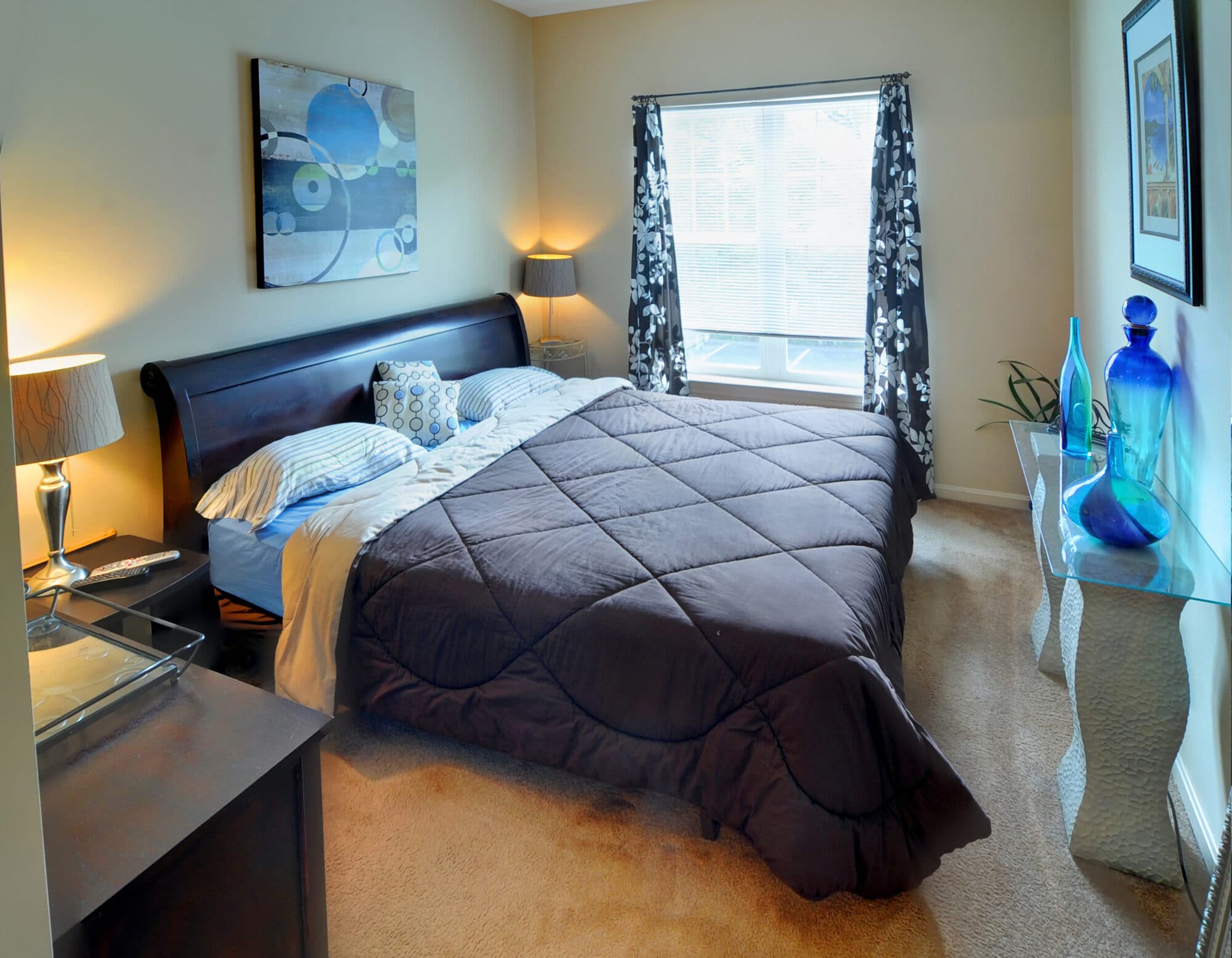 Spacious bedroom with large windows and wall-to-wall carpeting.